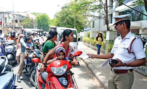 City traffic police distributes helmet awareness notices to women two-wheeler riders in T Nagar (Photo: DC) City traffic police distributes helmet awareness notices to women two-wheeler riders in T Nagar (Photo: DC)